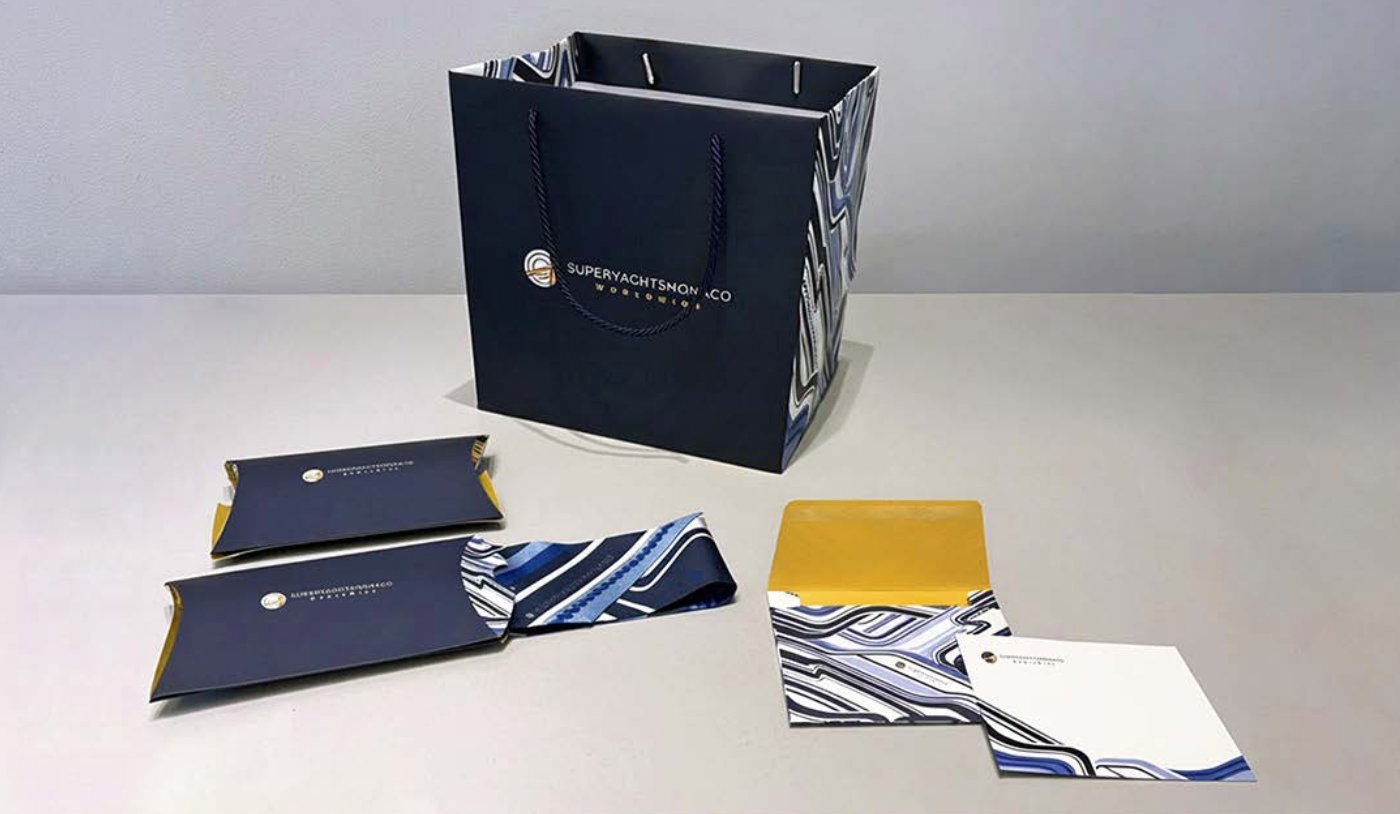 SuperYachtsMonaco branded merchandise — tote bag, silk twilly, stationery and packaging MYS 2025